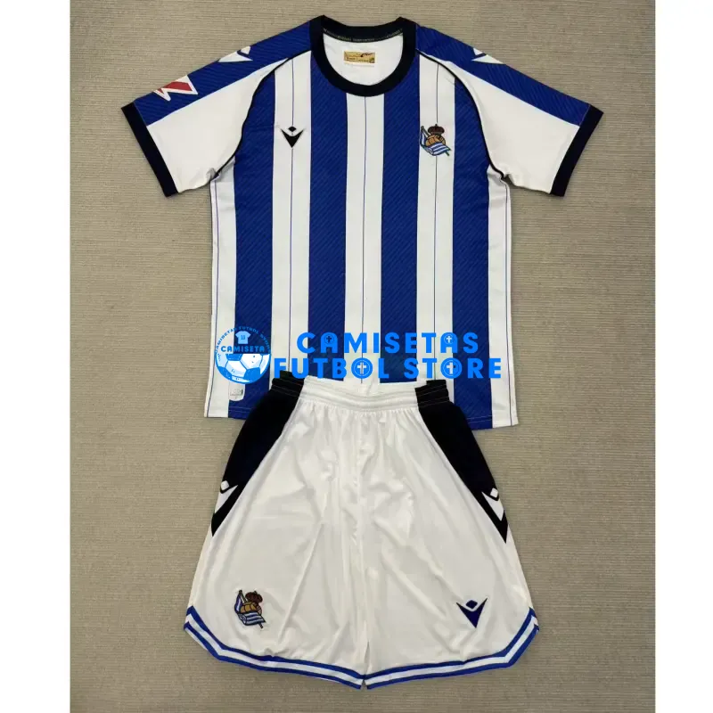Camiseta Real Sociedad 1ª Equipación 2025/2026 Azul/Blanco Niño Kit con Parche La Liga